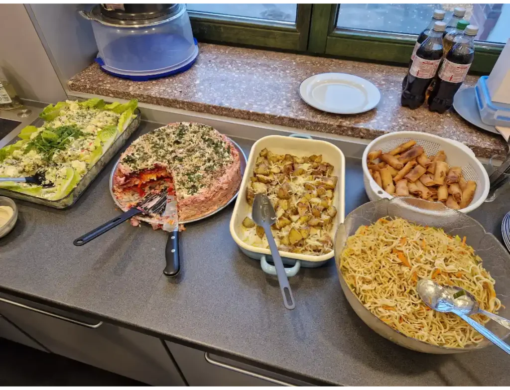 Das Bild zeigt mehrere Speisen, die auf einem Buffet stehen.