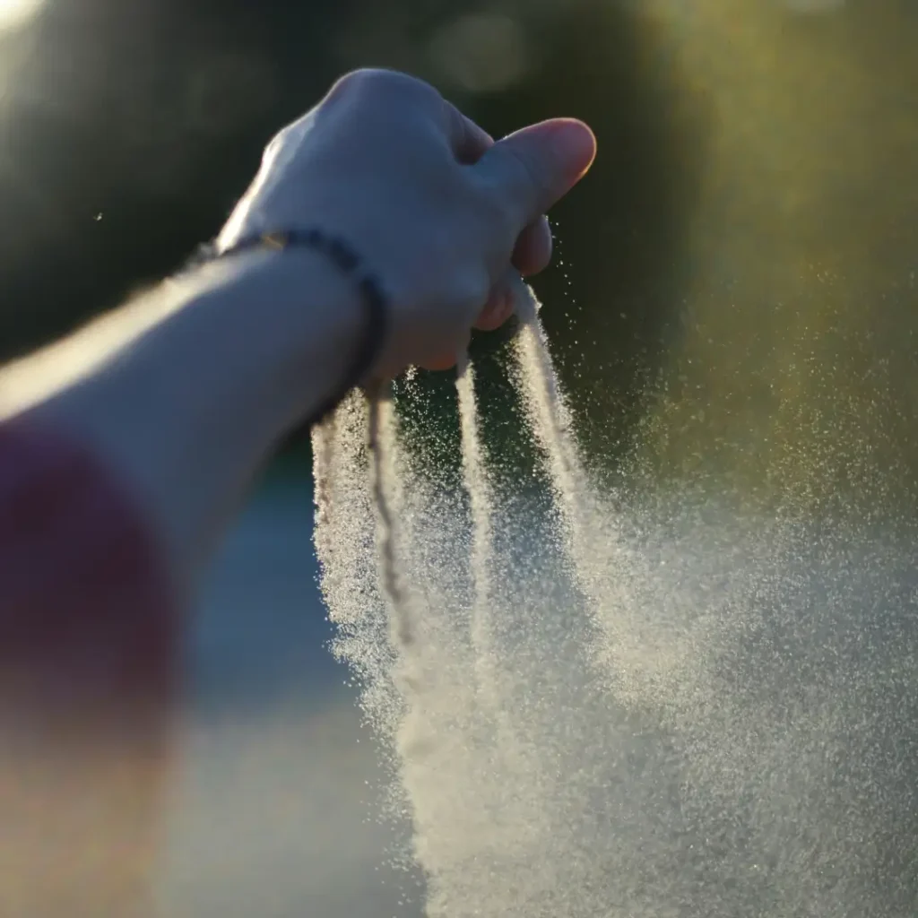 Ein linker Arm ist nach vorne ausgestreckt. Die Hand ist eine leichte Faust aus der Wasser sprüht.